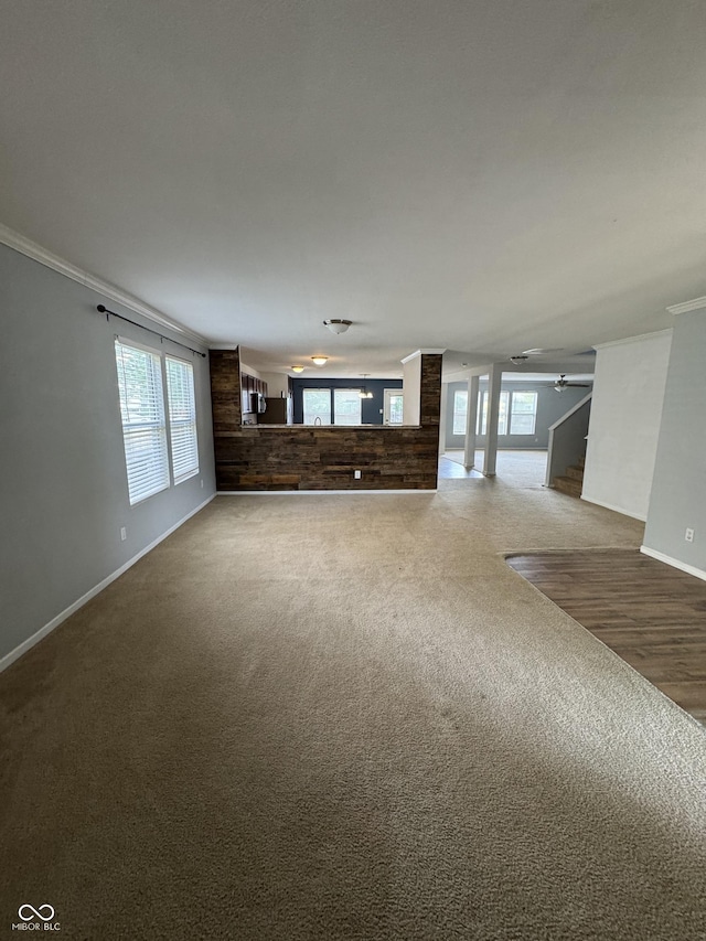 2307 Blackthorn Dr, Franklin, IN 46131 - unfurnished living room with carpet floors, ceiling fan, baseboards, crown molding, and plenty of natural light
