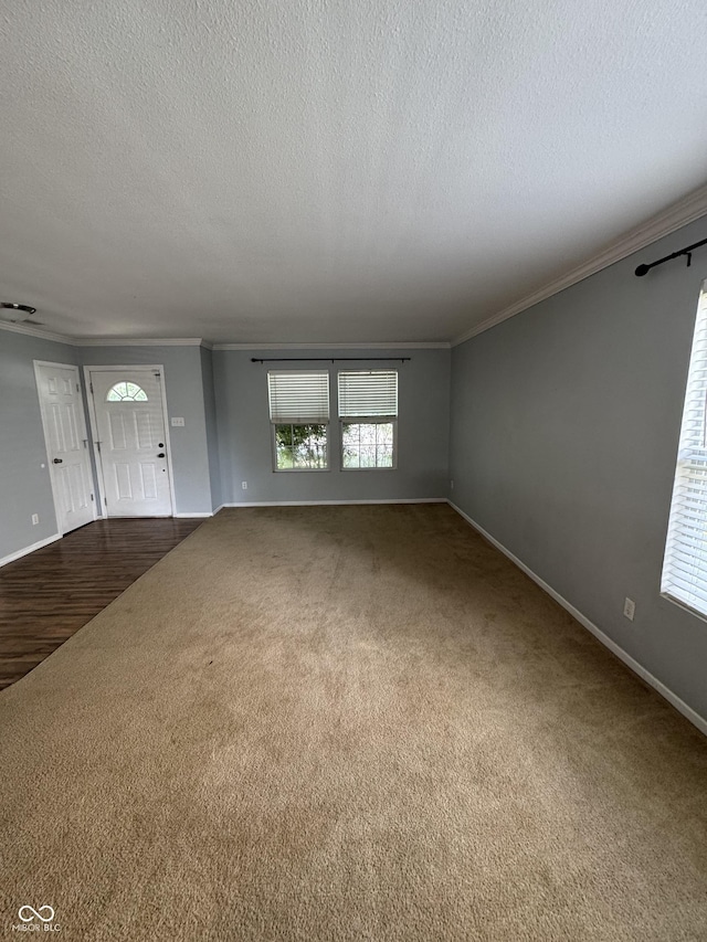 2307 Blackthorn Dr, Franklin, IN 46131 - unfurnished living room featuring crown molding, dark carpet, a textured ceiling, and baseboards