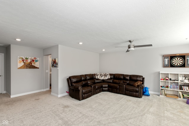 carpeted living room featuring ceiling fan and a textured ceiling