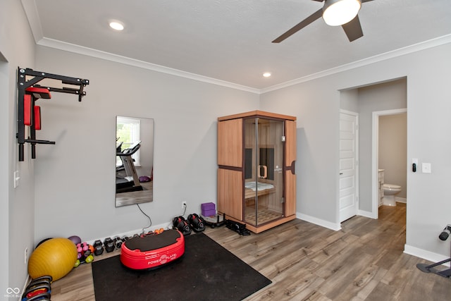 exercise area with ceiling fan, crown molding, and hardwood / wood-style floors