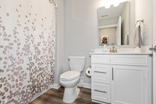 bathroom featuring wood-type flooring, vanity, toilet, and curtained shower