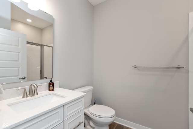 bathroom featuring hardwood / wood-style floors, an enclosed shower, vanity, and toilet