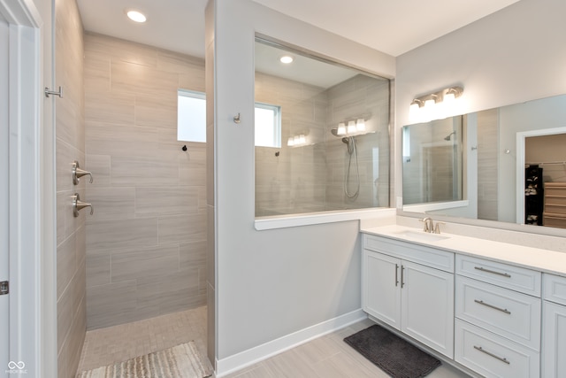 bathroom with vanity, tile patterned flooring, and a tile shower