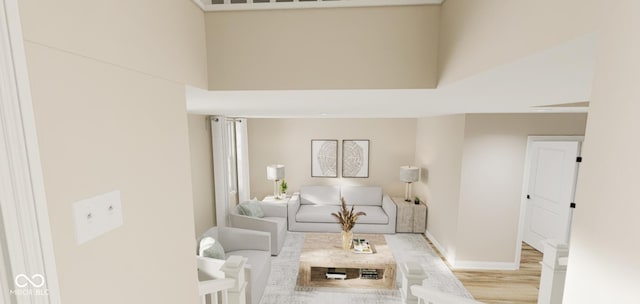 living room featuring a high ceiling and light hardwood / wood-style flooring