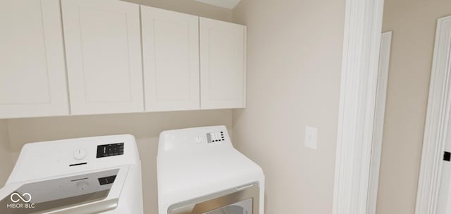 laundry room featuring washer and clothes dryer and cabinets