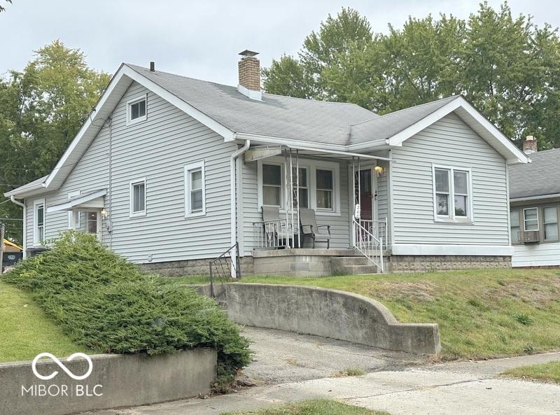 view of front of home featuring a chimney and a front lawn