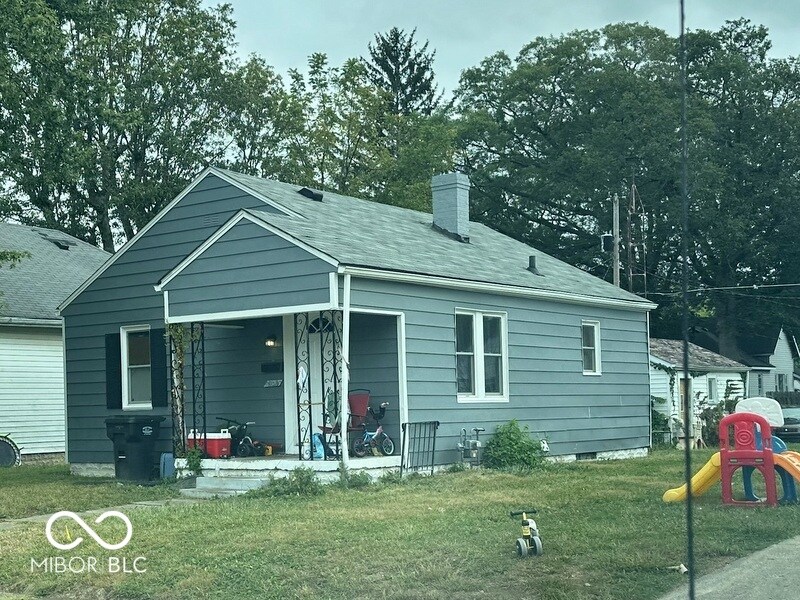 rear view of house with a playground, a yard, and covered porch