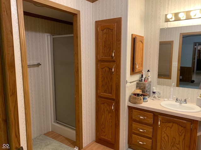 bathroom with vanity, hardwood / wood-style floors, and an enclosed shower