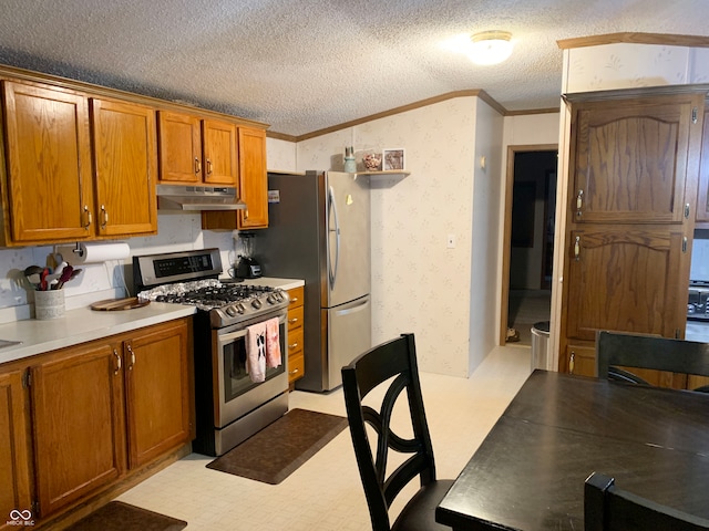 kitchen with ornamental molding, light colored carpet, a textured ceiling, and appliances with stainless steel finishes