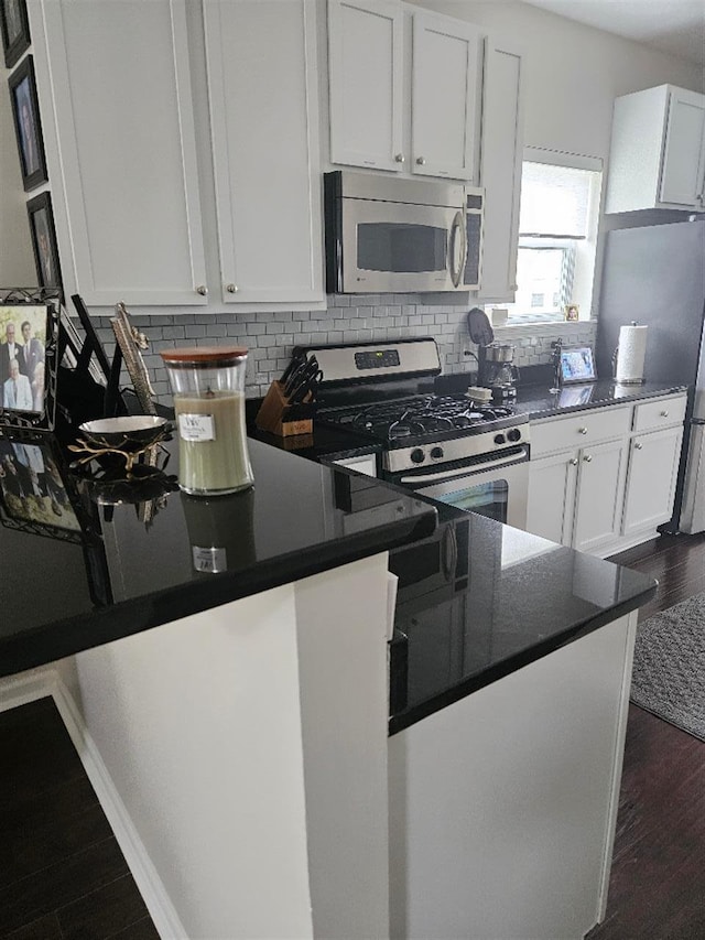 kitchen with stainless steel appliances, white cabinetry, and dark hardwood / wood-style flooring