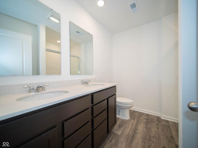 bathroom with hardwood / wood-style flooring, vanity, and toilet