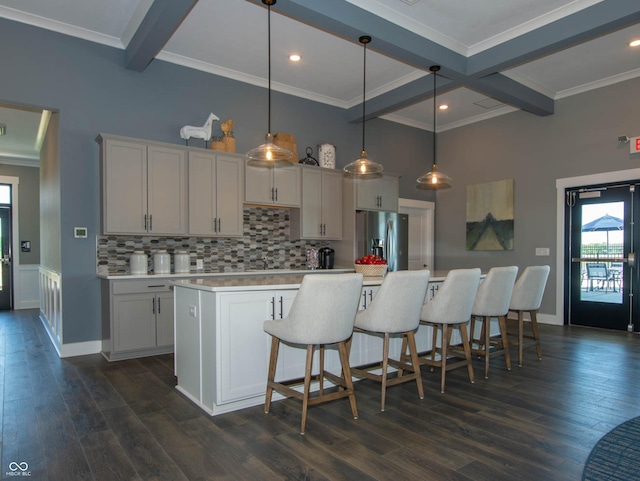 kitchen featuring stainless steel fridge, dark wood-style flooring, beamed ceiling, light countertops, and backsplash