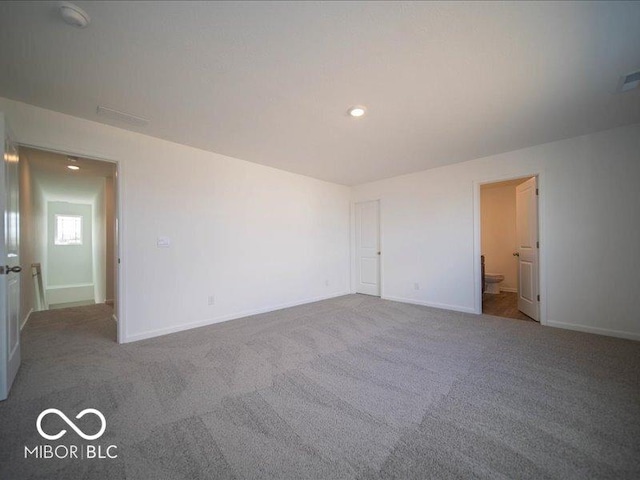 carpeted empty room with visible vents and baseboards