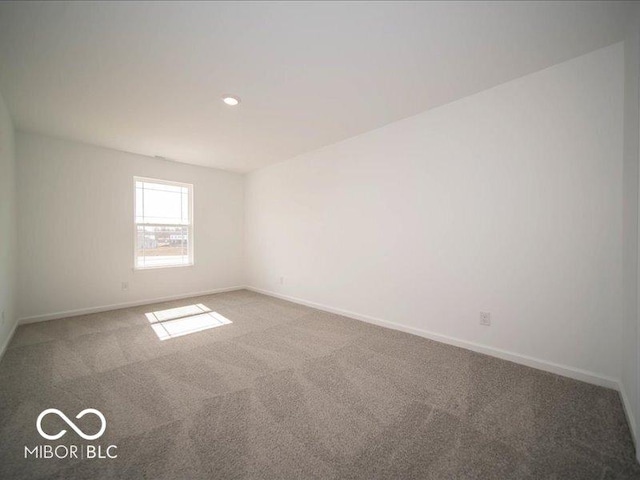 carpeted spare room featuring baseboards and recessed lighting