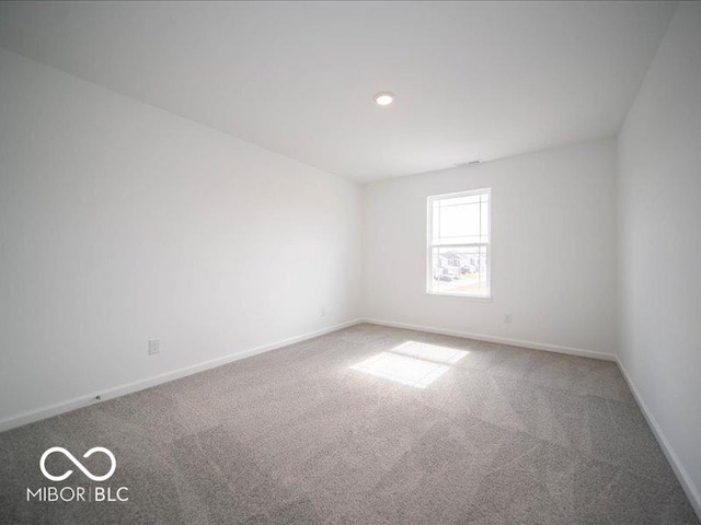 carpeted empty room featuring baseboards