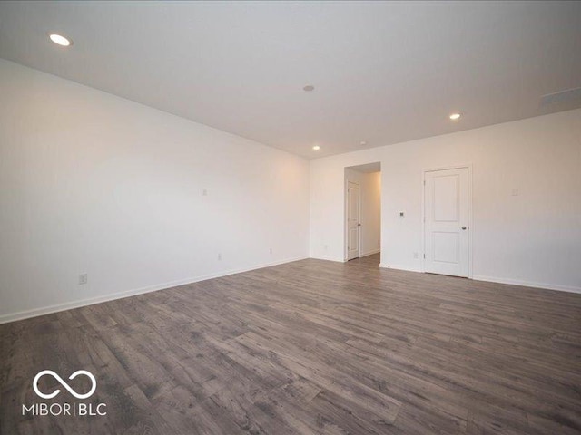 unfurnished room featuring baseboards, wood finished floors, and recessed lighting