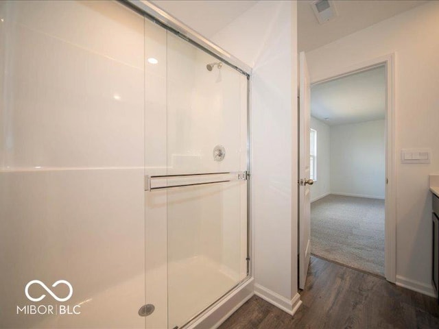 full bath with a stall shower, baseboards, wood finished floors, and vanity