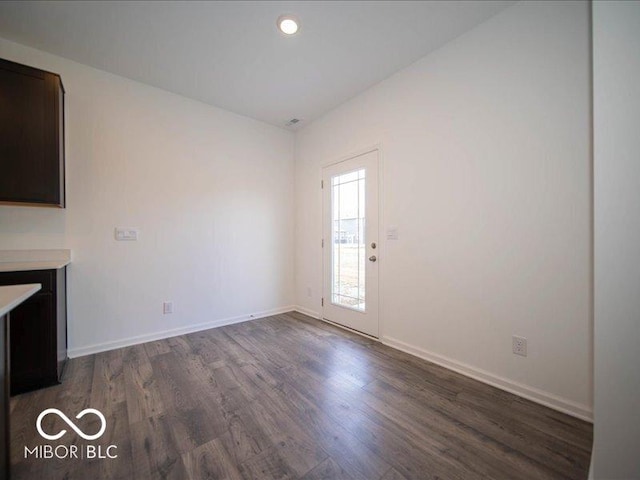 unfurnished living room with recessed lighting, dark wood finished floors, and baseboards