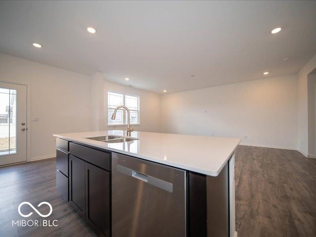 kitchen featuring dishwasher, an island with sink, open floor plan, dark wood-type flooring, and a sink