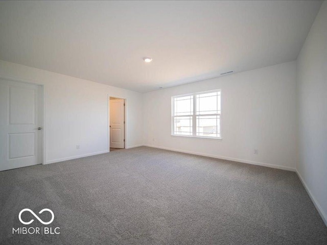 unfurnished room featuring carpet floors and baseboards