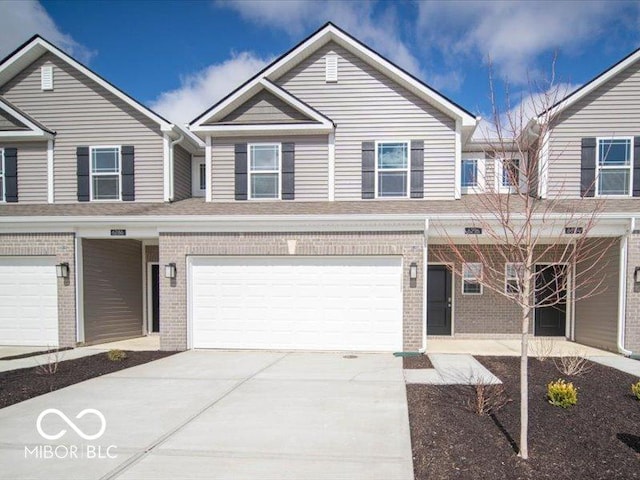 multi unit property with driveway, a garage, and brick siding