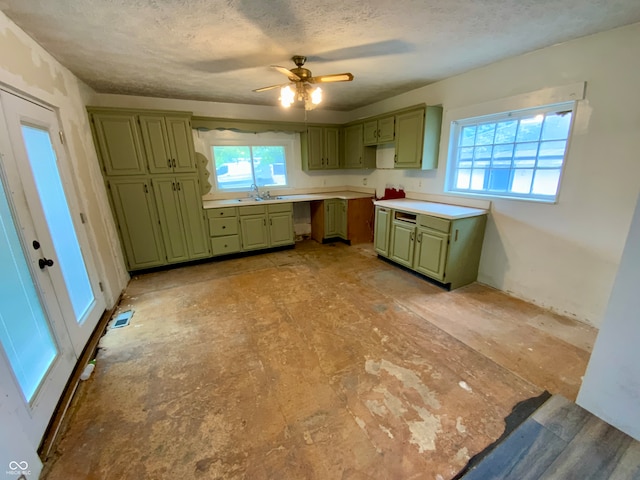 kitchen featuring ceiling fan, a textured ceiling, and green cabinets