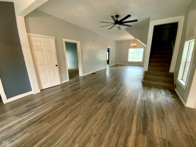 unfurnished living room with ceiling fan with notable chandelier and dark hardwood / wood-style floors