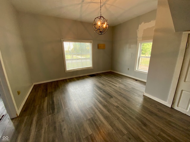 unfurnished room featuring dark wood-type flooring and a chandelier