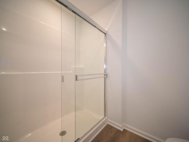 bathroom featuring hardwood / wood-style flooring and a shower with shower door