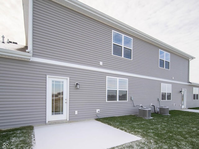 rear view of property featuring cooling unit, a patio, and a lawn