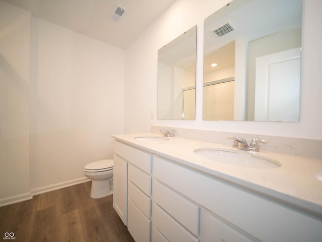 bathroom with vanity, hardwood / wood-style flooring, an enclosed shower, and toilet