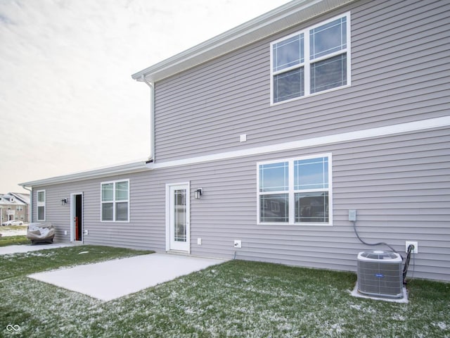 back of house with a lawn, central AC unit, and a patio