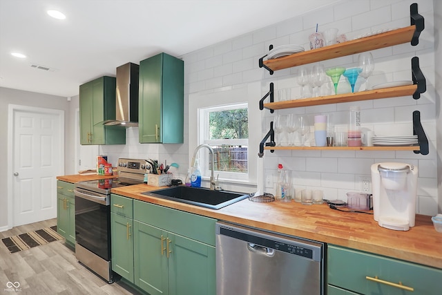 kitchen featuring sink, appliances with stainless steel finishes, green cabinets, and wooden counters