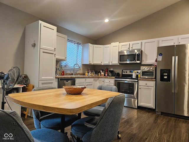 kitchen featuring dark wood-style flooring, lofted ceiling, white cabinetry, a sink, and appliances with stainless steel finishes