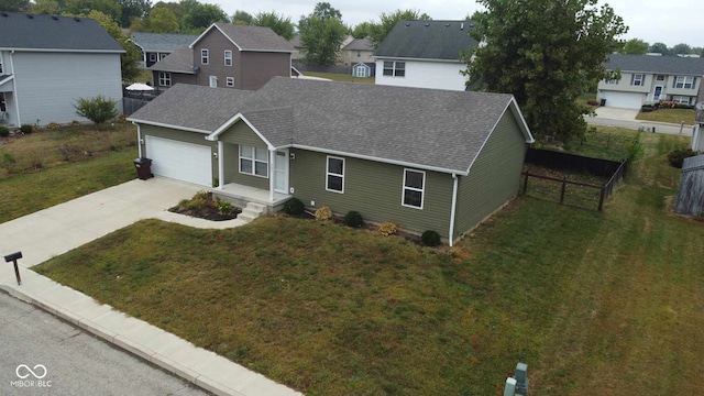view of front of house with fence, roof with shingles, a front lawn, a garage, and driveway