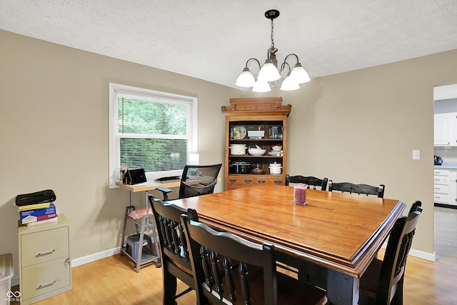 2747 E Midland Rd, Indianapolis, IN 46227 - dining area featuring a chandelier, light wood-type flooring, baseboards, and a textured ceiling