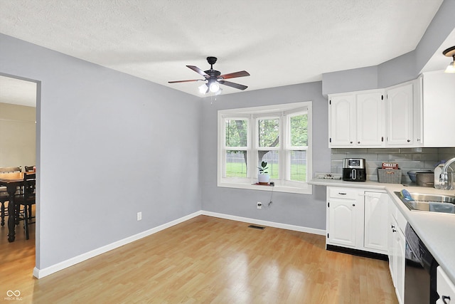 2747 E Midland Rd, Indianapolis, IN 46227 - kitchen with black dishwasher, a sink, light wood-type flooring, white cabinetry, and a ceiling fan