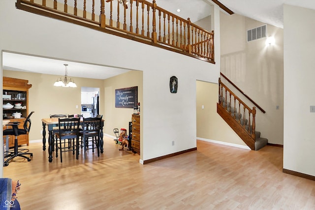 2747 E Midland Rd, Indianapolis, IN 46227 - dining space featuring a towering ceiling, wood finished floors, stairs, baseboards, and a chandelier