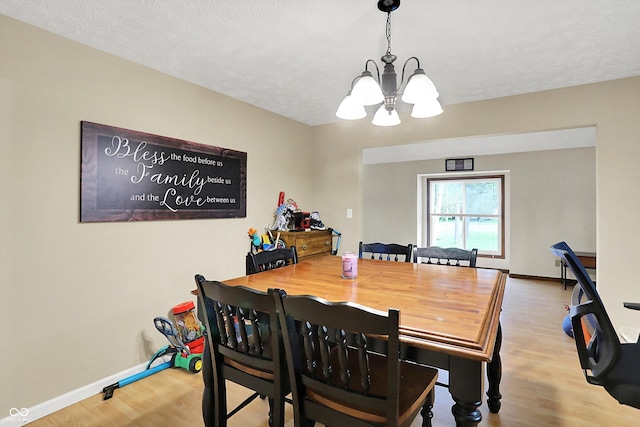 2747 E Midland Rd, Indianapolis, IN 46227 - dining space with a chandelier, wood finished floors, baseboards, and a textured ceiling