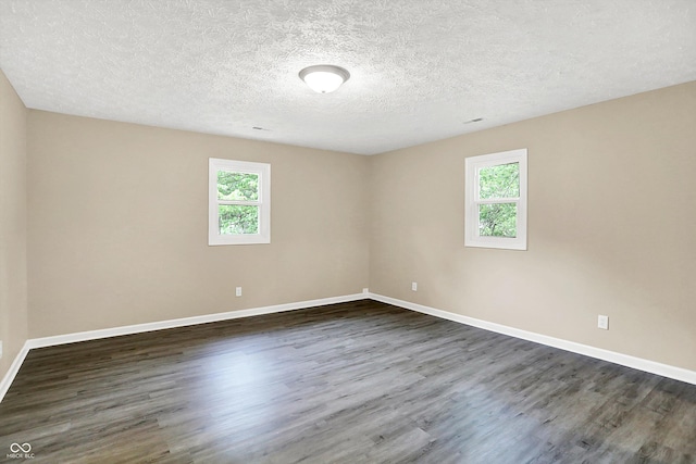 2747 E Midland Rd, Indianapolis, IN 46227 - empty room featuring healthy amount of natural light, dark wood-style flooring, baseboards, and a textured ceiling
