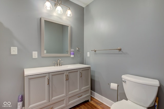 bathroom with vanity, hardwood / wood-style flooring, and toilet