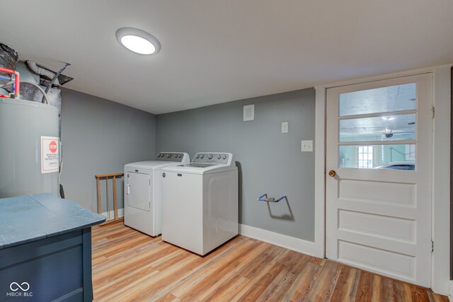 laundry area with water heater, light hardwood / wood-style floors, and independent washer and dryer