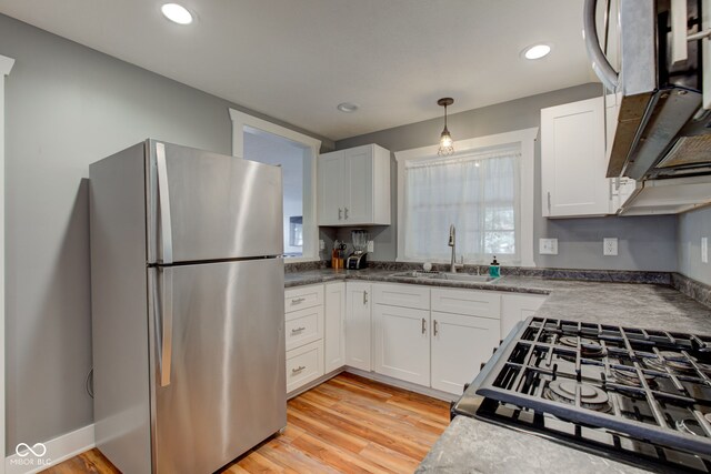 kitchen featuring light hardwood / wood-style floors, sink, stainless steel appliances, and white cabinets