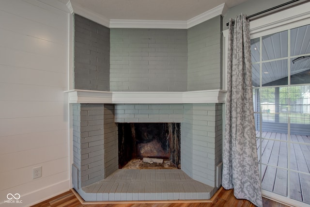 details with a brick fireplace, hardwood / wood-style flooring, and crown molding