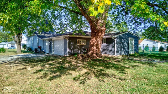 ranch-style home with a garage and a front lawn