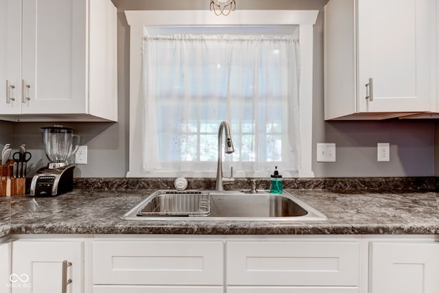 kitchen featuring white cabinetry and sink