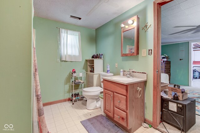 bathroom featuring a textured ceiling, vanity, and toilet