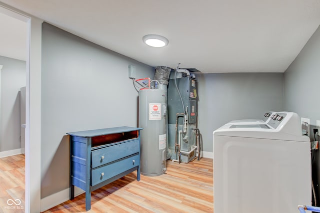 clothes washing area with water heater, separate washer and dryer, baseboards, laundry area, and wood finished floors