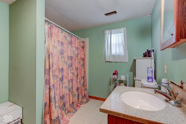bathroom with baseboards, a shower with shower curtain, vanity, and a textured ceiling