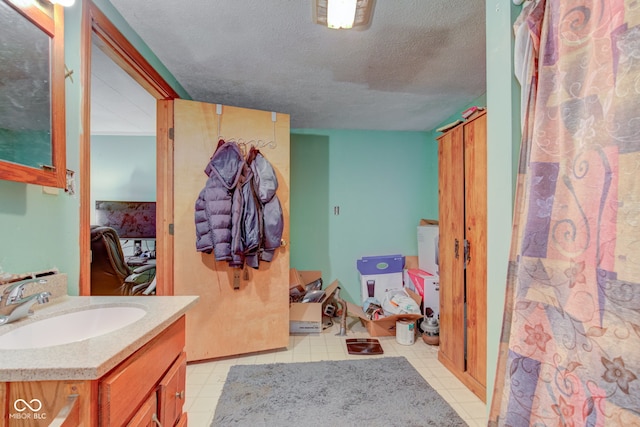 bathroom featuring a textured ceiling, tile patterned flooring, and vanity